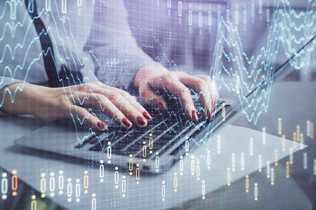 Multi exposure of woman hands typing on computer and financial graph hologram drawing. Stock market...
