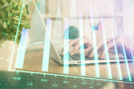 Double exposure of woman hands typing on computer and forex chart hologram drawing. Stock market invest concept.の写真素材