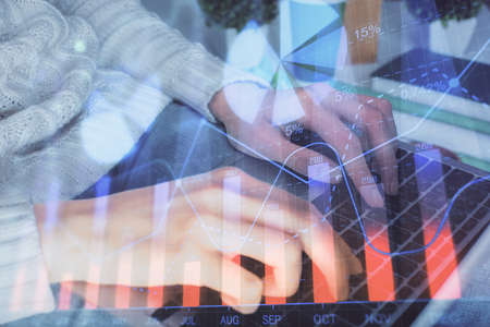 Double exposure of woman hands typing on computer and forex chart hologram drawing. Stock market invest concept.の写真素材