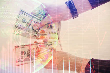 Multi exposure of financial graph drawing hologram and USA dollars bills and man hands. Analysis...