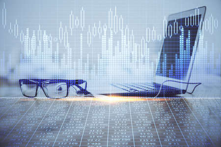 Financial graph colorful drawing and table with computer on background. Double exposure. Concept of international markets.の写真素材