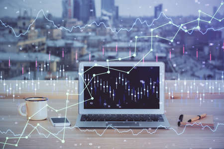 Double exposure of chart and financial info and work space with computer background. Concept of international online trading.の写真素材