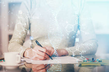 DNA theme hologram over womans hands writing background. Concept of education. Double exposureの写真素材