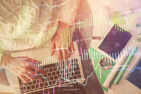 Multi exposure of woman hands working on computer and forex chart hologram drawing. Top View....