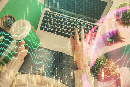 Double exposure of woman hands working on computer and forex chart hologram drawing. Top View....