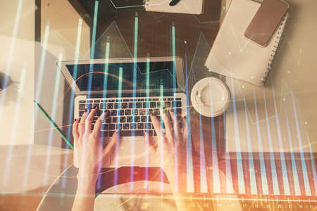 Double exposure of woman hands working on computer and forex chart hologram drawing. Top View....