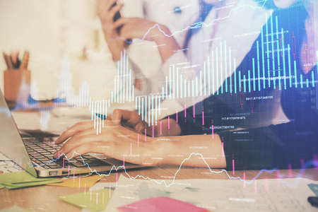 Multi exposure of woman hands typing on computer and financial graph hologram drawing. Stock market...