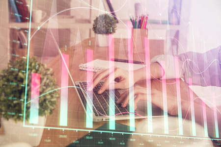 Double exposure of woman hands typing on computer and forex chart hologram drawing. Stock market invest concept.の写真素材