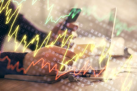 Double exposure of mans hands holding and using a phone and financial graph drawing. Analysis...