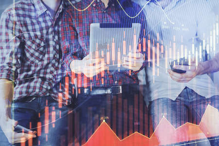 Double exposure of forex graph drawing and man and woman working together holding and using a mobile device. Trade concept.の写真素材