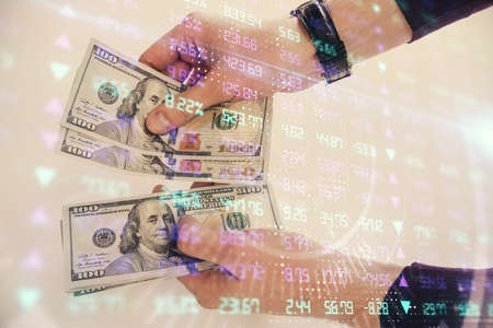 Multi exposure of financial graph drawing hologram and USA dollars bills and man hands. Analysis...