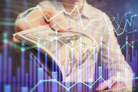 Multi exposure of financial graph drawing hologram and USA dollars bills and man hands. Analysis...