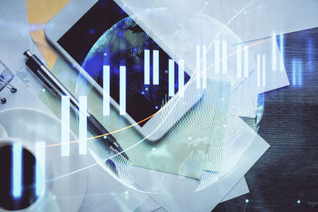 Multi exposure of forex graph hologram over desktop with phone. Top view. Mobile trade platform...