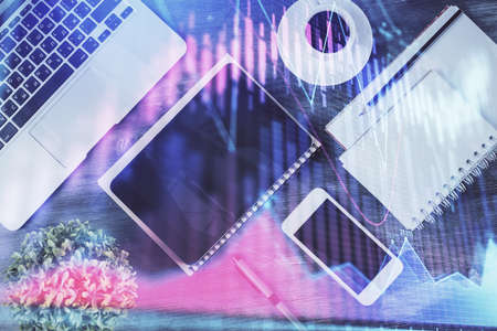 Double exposure of forex chart hologram over desktop with phone. Top view. Mobile trade platform concept.の写真素材