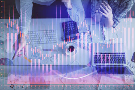 Double exposure of man and woman working together and financial graph hologram drawing. market analysis concept. Computer background. Top View.の写真素材