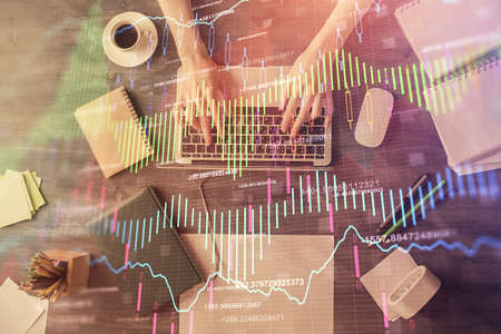 Multi exposure of woman hands working on computer and forex chart hologram drawing. Top View....