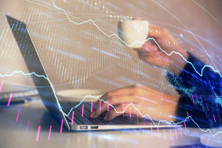 Double exposure of businesswoman hands typing on computer and forex graph hologram drawing....