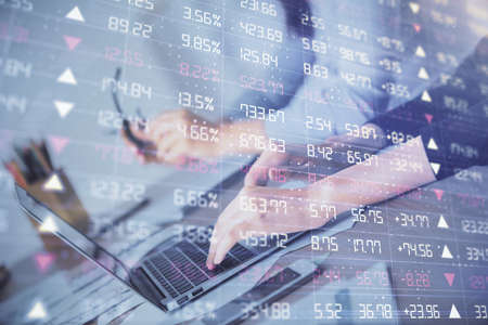Multi exposure of woman hands typing on computer and financial chart hologram drawing. Stock market...