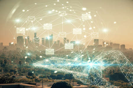 Double exposure of envelop hologram flying from gadget and city view background. Concept e-mail.