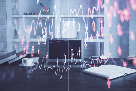 Stock market chart hologram drawn on personal computer background. Double exposure. Concept of investment.の写真素材