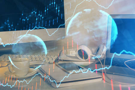 Financial chart drawing and table with computer on background. Multi exposure. Concept of...