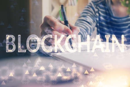 Cryptocurrency hologram, bitcoin, ico theme over hands taking notes background. Concept of...