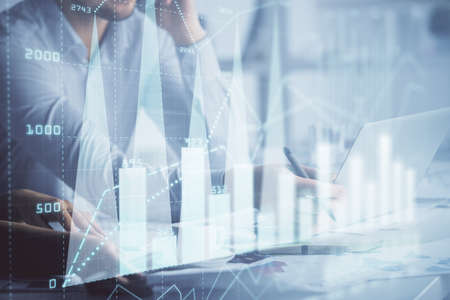 Double exposure of man and woman working together and financial graph hologram. Business concept....