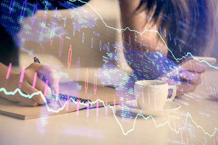 Double exposure of forex graph sketch hologram and woman holding and using a mobile device. Stock...
