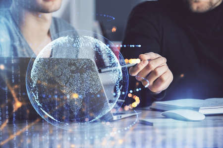 Double exposure of world map hologram with man working on computer on background. Concept of worldwideweb.の写真素材