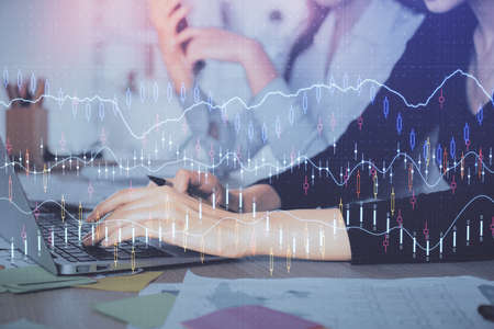Multi exposure of woman hands typing on computer and financial graph hologram drawing. Stock market...