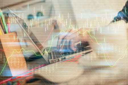 Double exposure of woman hands typing on computer and forex chart hologram drawing. Stock market invest concept.の写真素材
