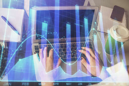 Double exposure of woman hands typing on computer and forex chart hologram drawing. Stock market...
