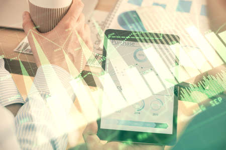 Double exposure of mans hands holding and using a phone and financial chart drawing. Market analysis concept.の写真素材