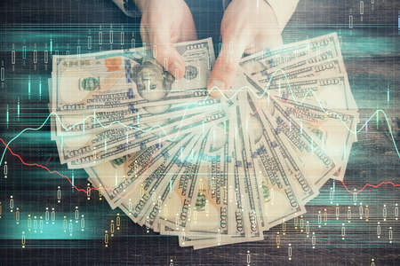 Multi exposure of financial graph drawing hologram and USA dollars bills and man hands. Analysis concept.の写真素材