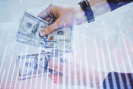 Multi exposure of financial graph drawing hologram and USA dollars bills and man hands. Analysis concept.の写真素材