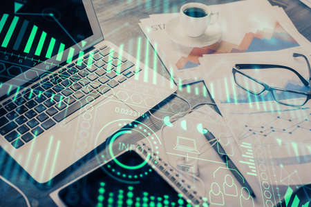 Computer on desktop in office with technology theme hologram. Double exposure. Tech concept.