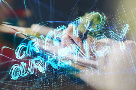 Cryptocurrency hologram, bitcoin, ico theme over hands taking notes background. Concept of...