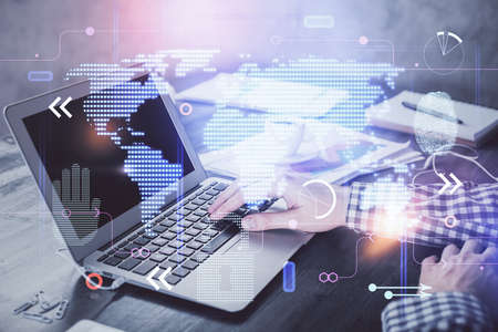 Multi exposure of world map hologram with man working on computer on background. Concept of...