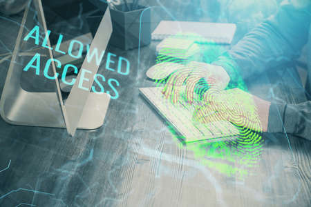 Fingerprint hologram with businessman working on computer on background. Security concept. Double...