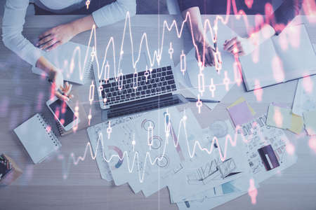 Double exposure of woman hands working on computer and forex graph hologram drawing. Top View....