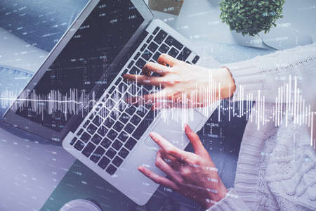 Double exposure of woman hands working on computer and forex chart hologram drawing. Top View....