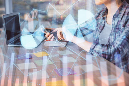 Double exposure of businesswoman hands typing on computer and forex graph hologram drawing....