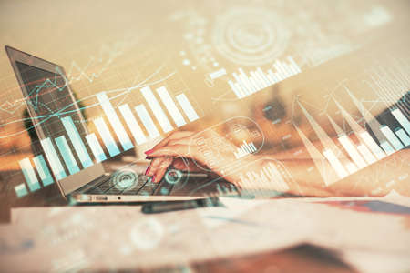 Double exposure of businesswoman hands typing on computer and forex chart hologram drawing....