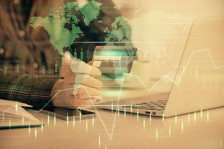 Multi exposure of woman on-line shopping holding a credit card and financial graph drawing. Stock...