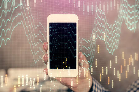 Double exposure of mans hands holding and using a digital device and forex graph drawing. Financial...