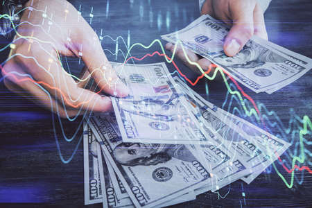 Multi exposure of financial graph drawing hologram and USA dollars bills and man hands. Analysis concept.の写真素材