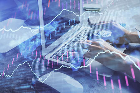 Double exposure of woman hands typing on computer and forex chart hologram drawing. Stock market...