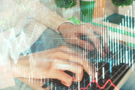 Double exposure of woman hands typing on computer and forex chart hologram drawing. Stock market...