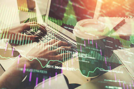 Double exposure of woman hands typing on computer and forex chart hologram drawing. Stock market...