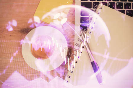 Double exposure of financial chart drawing over table background with computer. Concept of research...